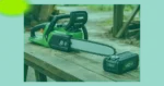 Eine grüne Akku-Kettensäge, die als eine der besten Akku-Kettensägen gilt und mit einem 40-V-Akku ausgestattet ist, liegt draußen auf einem Holztisch.